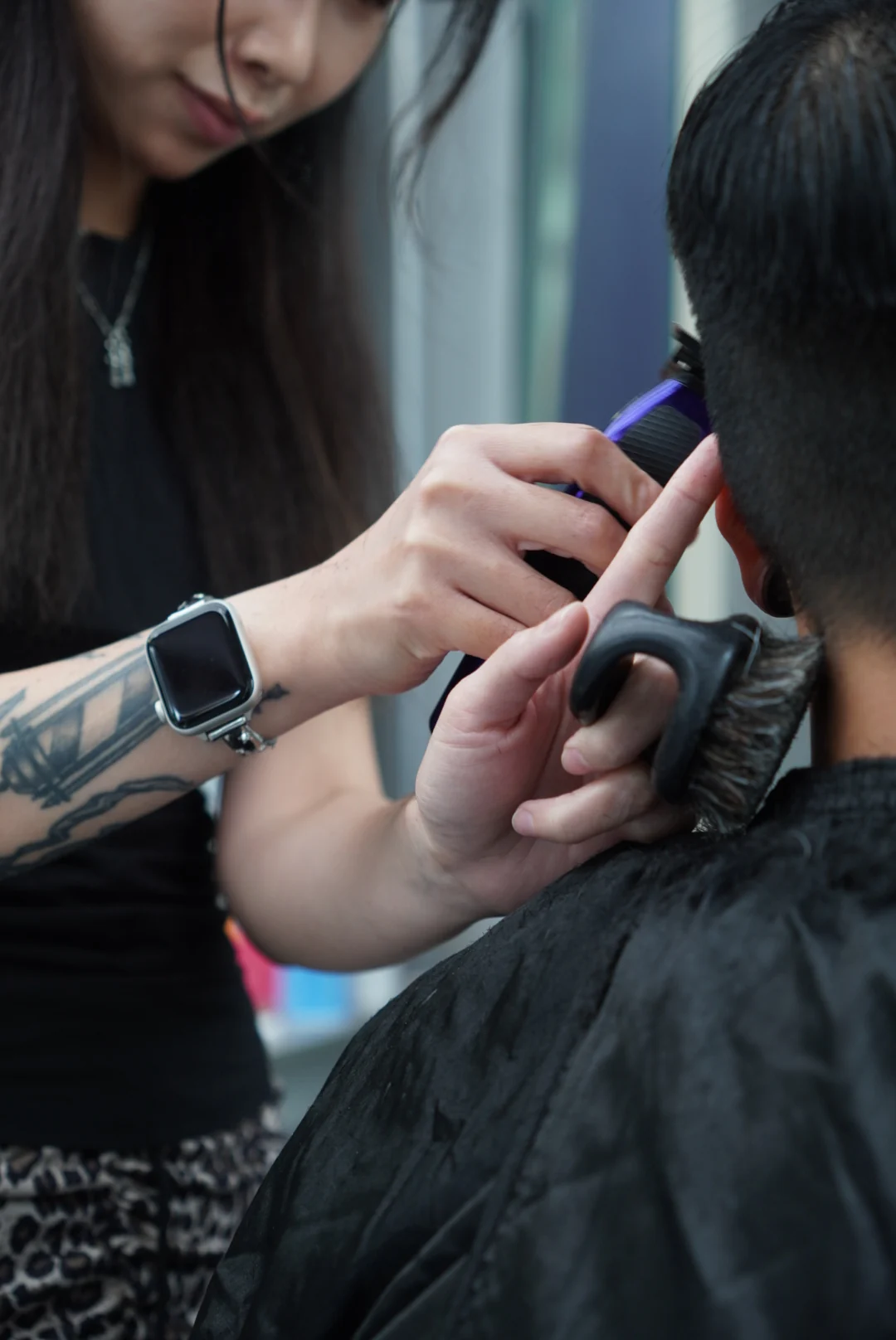 A close view of clippers shaping hair beside the ear