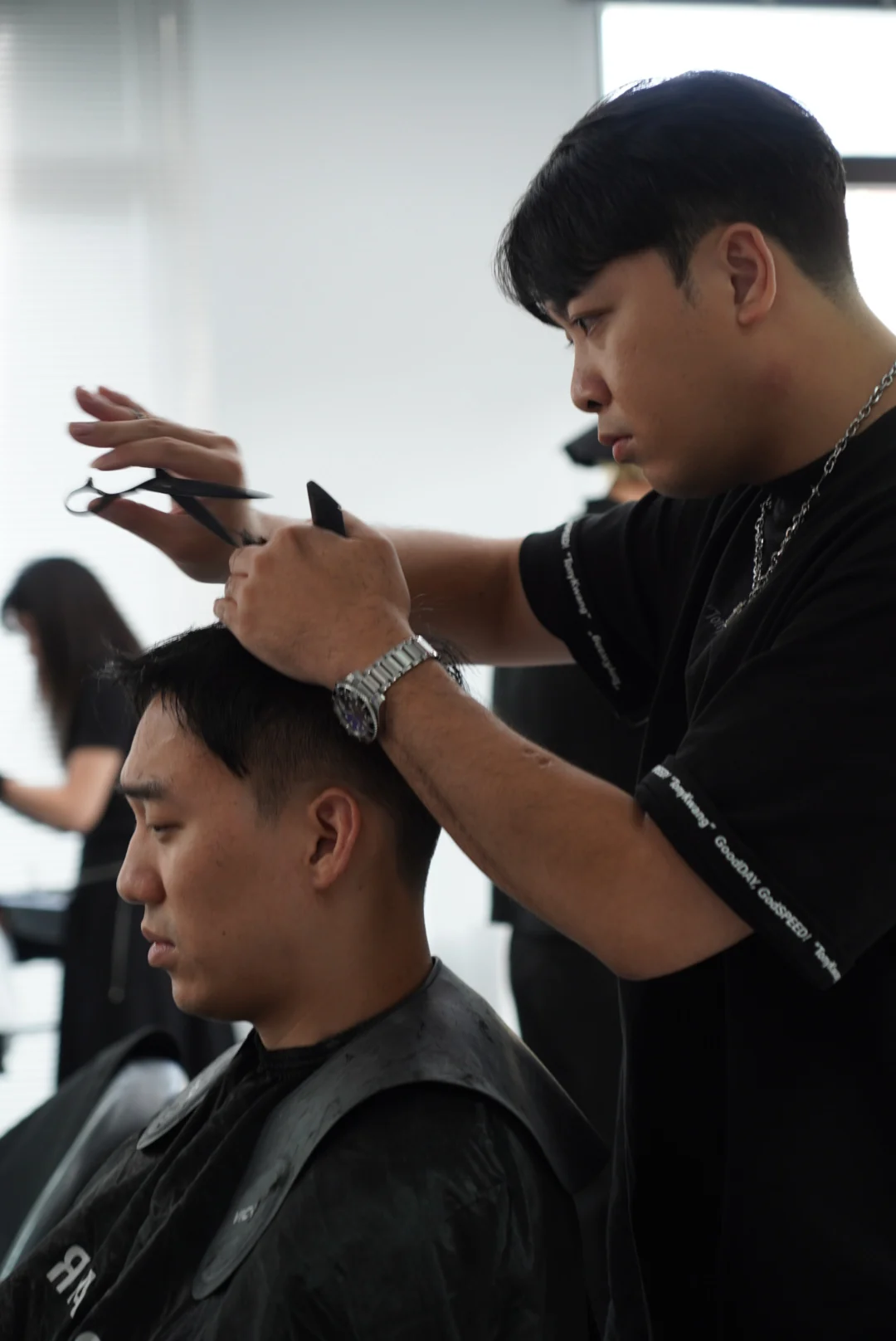 A side view of a designer concentrating on a section of hair