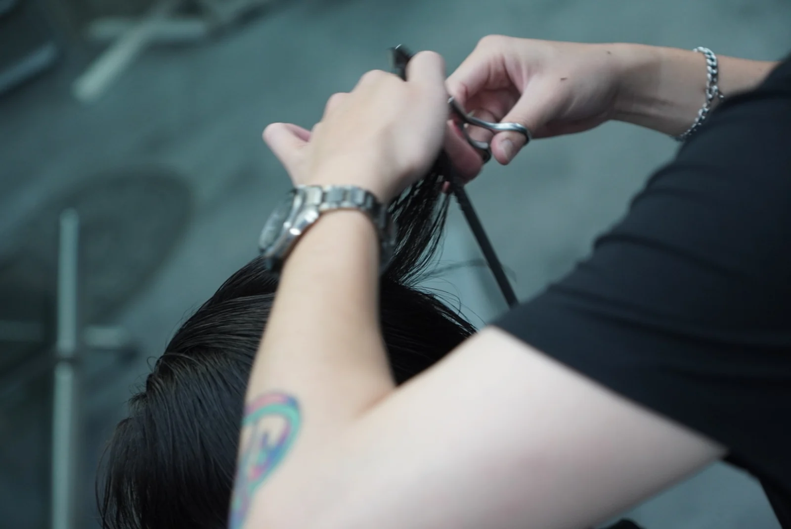 A close view of scissors and a comb working through a section of hair